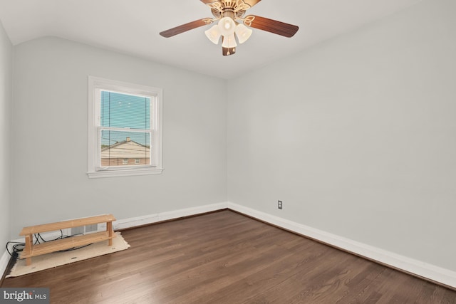 spare room with baseboards, ceiling fan, dark wood-style flooring, and lofted ceiling