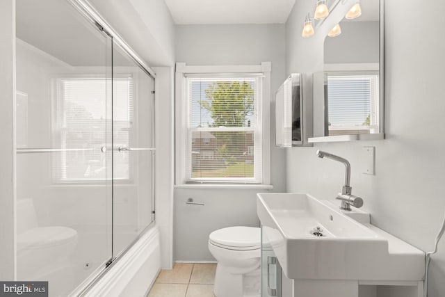 bathroom with a sink, tile patterned flooring, enclosed tub / shower combo, and toilet
