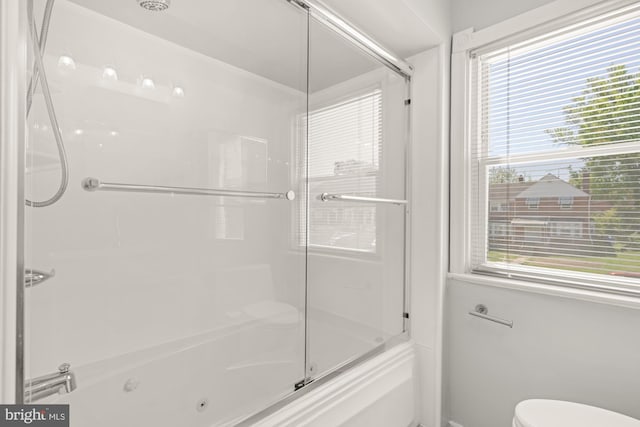 full bath featuring toilet and bath / shower combo with glass door