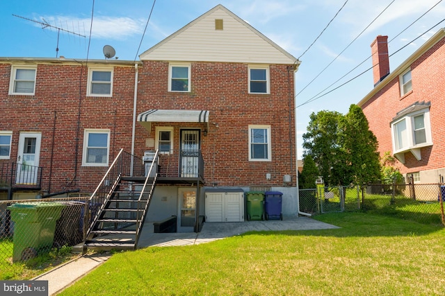 rear view of property with a yard, brick siding, a gate, and fence private yard