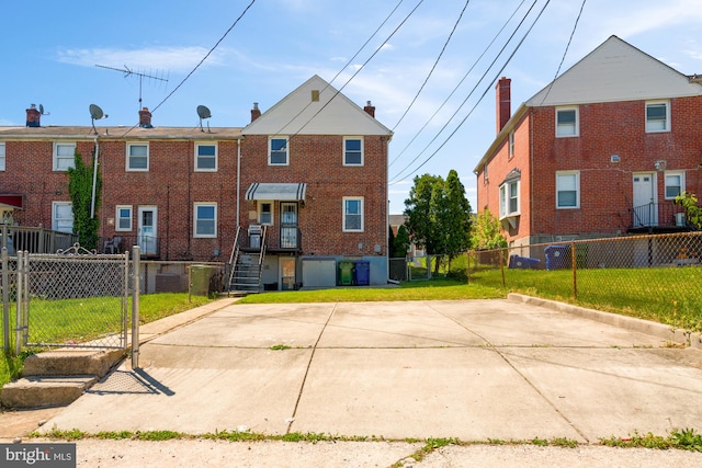 back of house with a yard, brick siding, a gate, and fence private yard