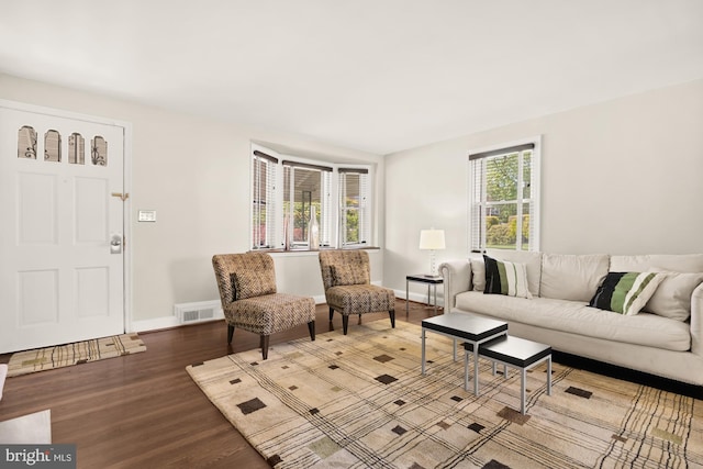 living area with baseboards, wood finished floors, and visible vents