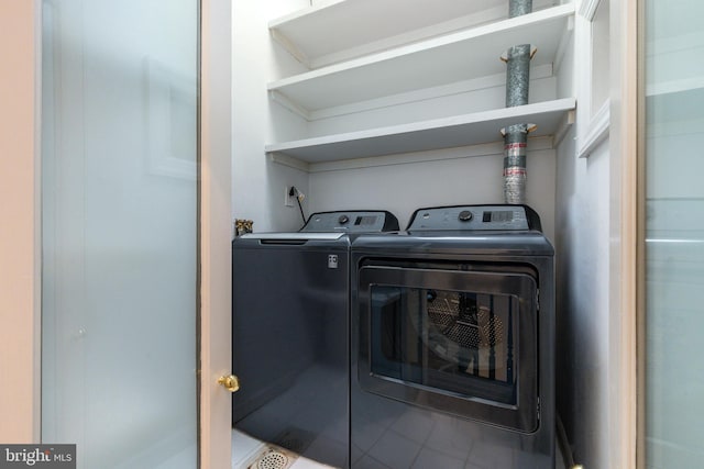 clothes washing area with laundry area, washer and clothes dryer, and tile patterned floors