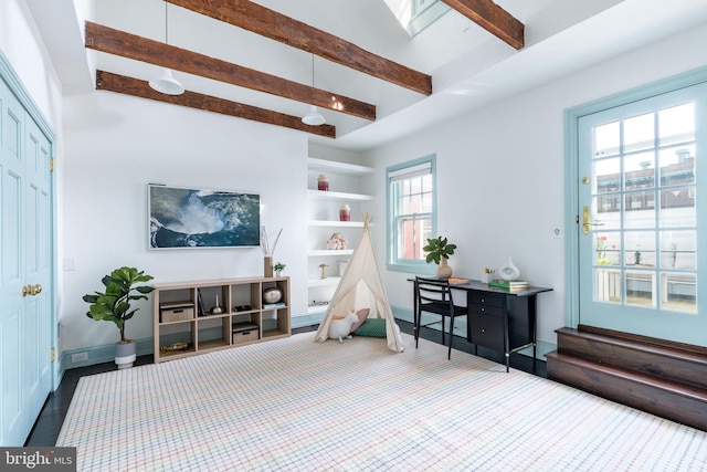 interior space with baseboards, built in features, and beam ceiling