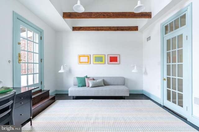 sitting room featuring baseboards, visible vents, and beam ceiling