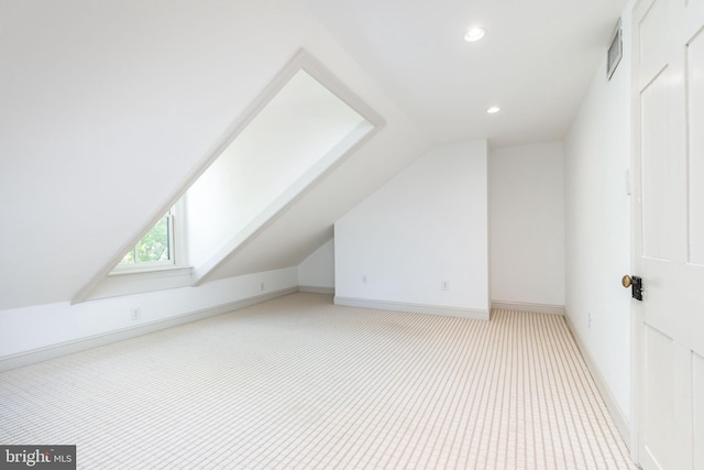 additional living space featuring visible vents, baseboards, lofted ceiling with skylight, light carpet, and recessed lighting