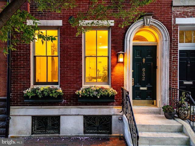 doorway to property featuring brick siding