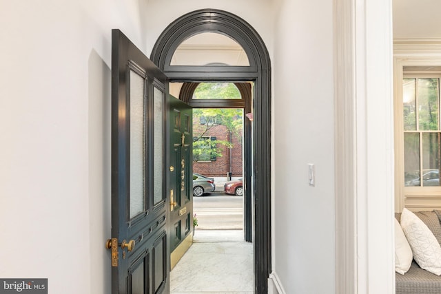 foyer entrance with baseboards and marble finish floor