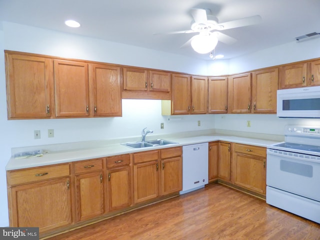 kitchen with visible vents, white appliances, ceiling fan, light countertops, and a sink