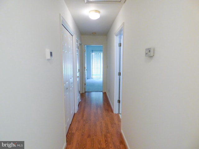 hallway with baseboards and wood finished floors