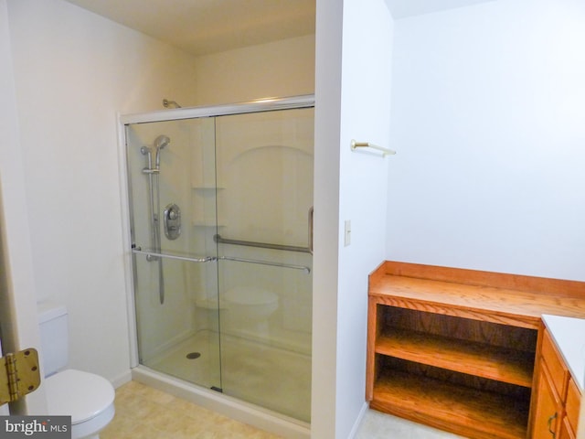 bathroom featuring baseboards, a stall shower, and toilet