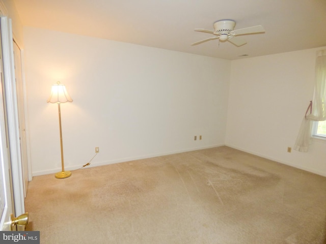 unfurnished room featuring baseboards, a ceiling fan, and light colored carpet