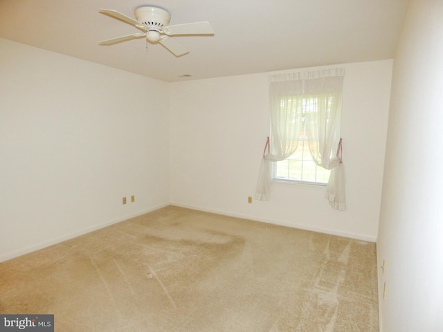 carpeted empty room with baseboards and ceiling fan