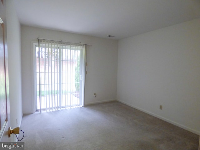 spare room with baseboards, carpet, and visible vents