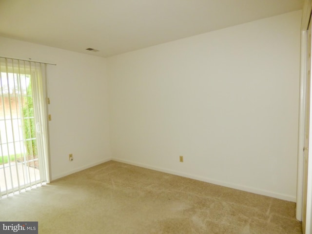 unfurnished room featuring light colored carpet, baseboards, and visible vents