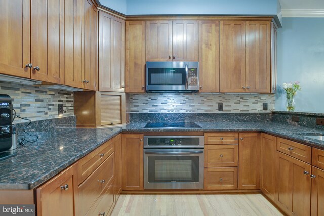 12868 Paddle Wheel Ct, Manassas, VA 20112 - kitchen featuring appliances with stainless steel finishes, brown cabinets, dark stone counters, and ornamental molding