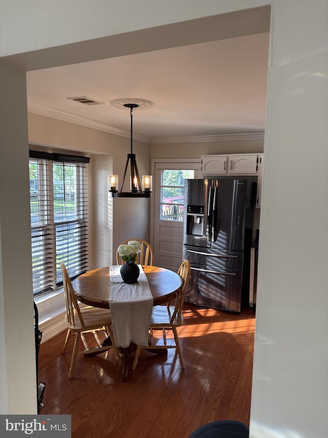 8549 Stonewall Rd, Manassas, VA 20110 - dining room featuring crown molding, an inviting chandelier, visible vents, and dark wood-type flooring