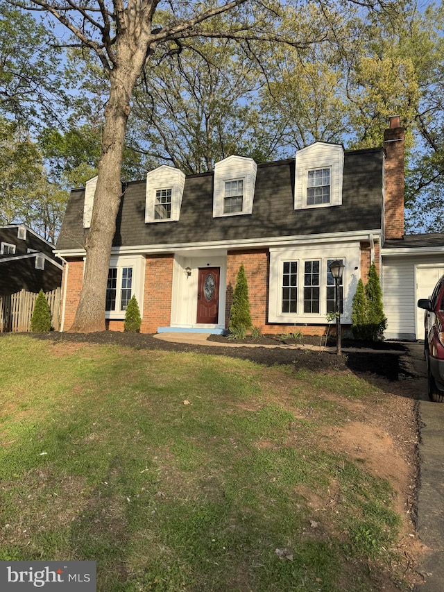 8549 Stonewall Rd, Manassas, VA 20110 - new england style home featuring a chimney, a shingled roof, brick siding, and a front lawn