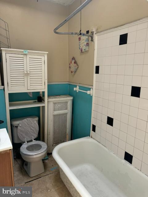 bathroom featuring toilet, wainscoting, tile patterned flooring, and vanity