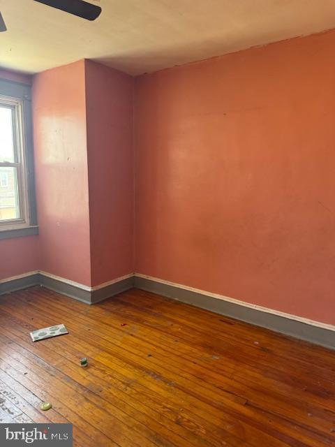 unfurnished room with wood-type flooring, baseboards, and ceiling fan