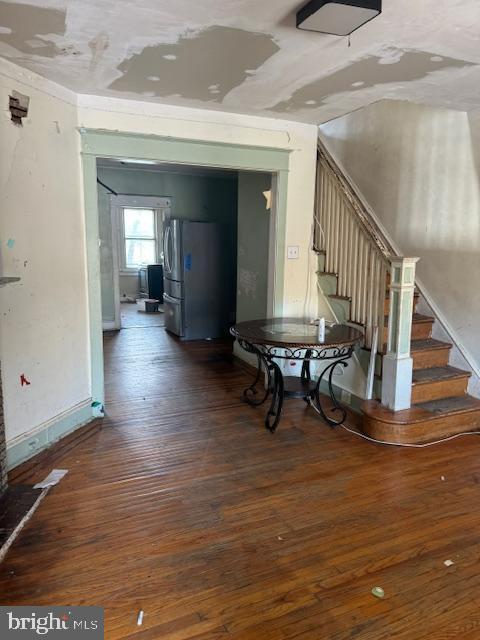 interior space featuring baseboards, stairs, and wood finished floors