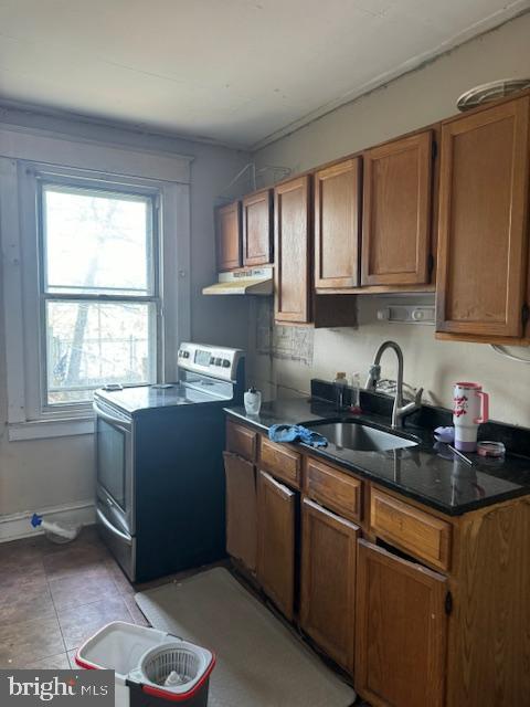 kitchen with brown cabinets, extractor fan, stainless steel electric stove, and a sink