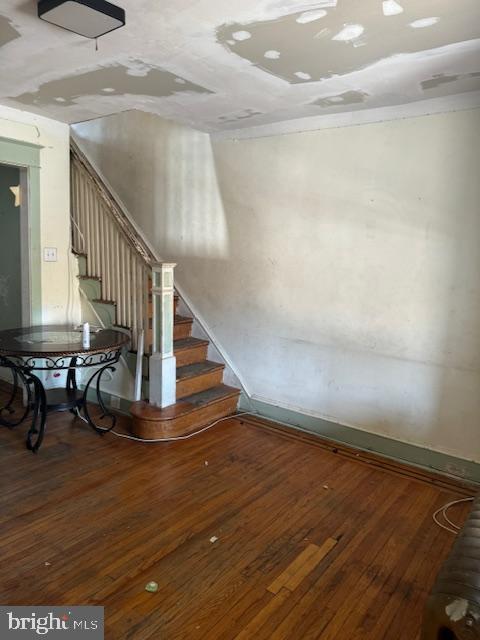 staircase featuring baseboards and hardwood / wood-style floors