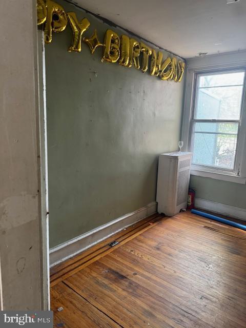 unfurnished room featuring baseboards and hardwood / wood-style flooring
