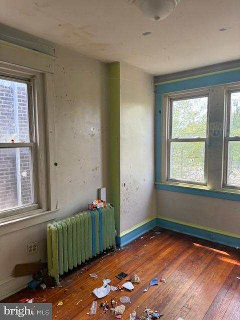 unfurnished room with wood-type flooring and radiator