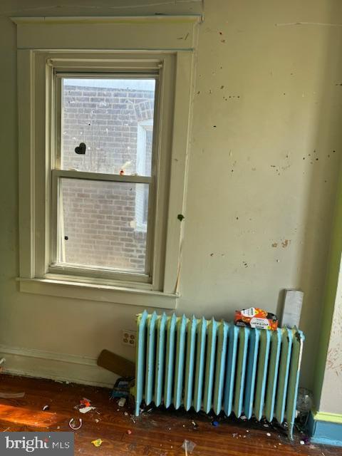 interior details featuring baseboards, radiator, and wood finished floors