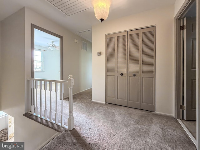 interior space featuring carpet floors, attic access, baseboards, an upstairs landing, and visible vents