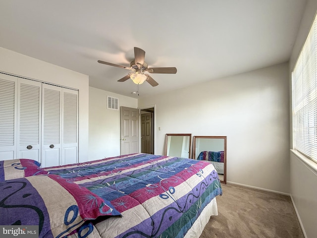 carpeted bedroom with baseboards, visible vents, multiple windows, and a closet