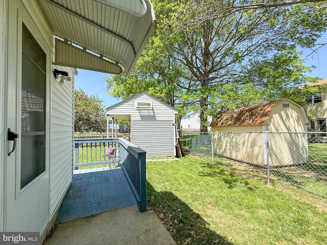 view of yard with an outdoor structure, a shed, and fence