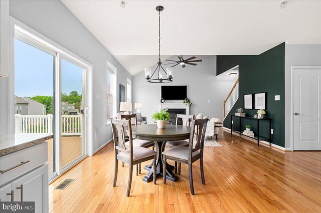 161 Stonecrest Cir, Keedysville, MD 21756 - dining area featuring stairs, light wood-style flooring, a fireplace, a chandelier, and baseboards
