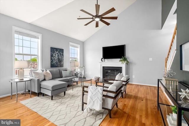 161 Stonecrest Cir, Keedysville, MD 21756 - living room featuring high vaulted ceiling, ceiling fan, wood finished floors, a glass covered fireplace, and stairs