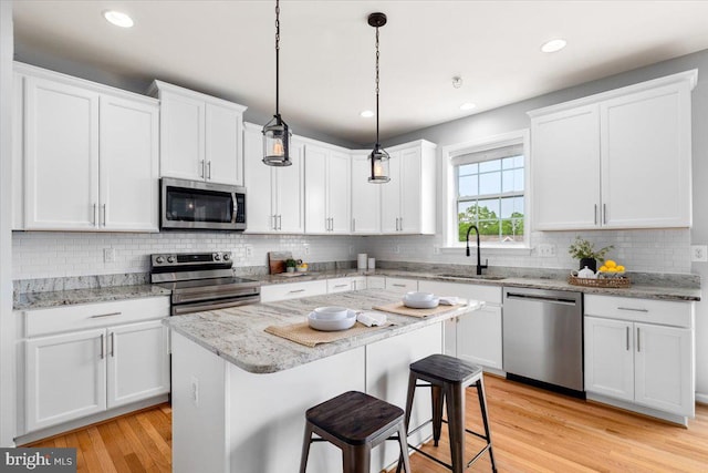 161 Stonecrest Cir, Keedysville, MD 21756 - kitchen with appliances with stainless steel finishes, a sink, white cabinetry, light wood-style flooring, and a breakfast bar