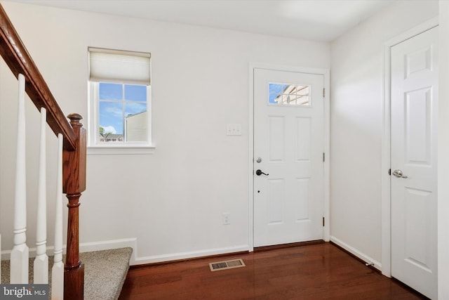 entryway featuring stairway, baseboards, dark wood-type flooring, and visible vents