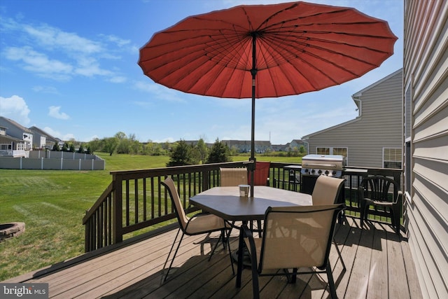 deck featuring outdoor dining space, a yard, and grilling area