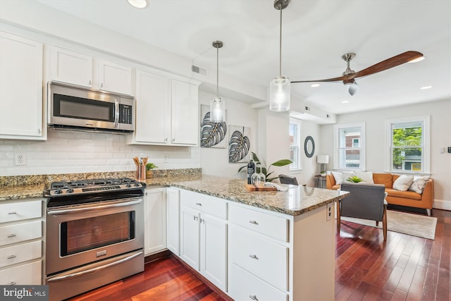 519 Somerset Pl NW, Washington, DC 20011 - kitchen featuring stainless steel appliances, a peninsula, open floor plan, white cabinetry, and backsplash