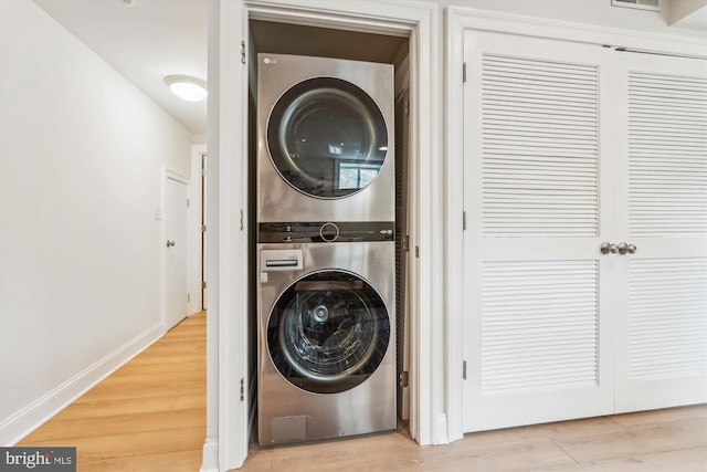 519 Somerset Pl NW, Washington, DC 20011 - clothes washing area featuring stacked washer / drying machine, wood finished floors, and baseboards
