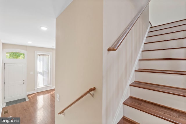 stairway featuring visible vents, recessed lighting, baseboards, and wood finished floors