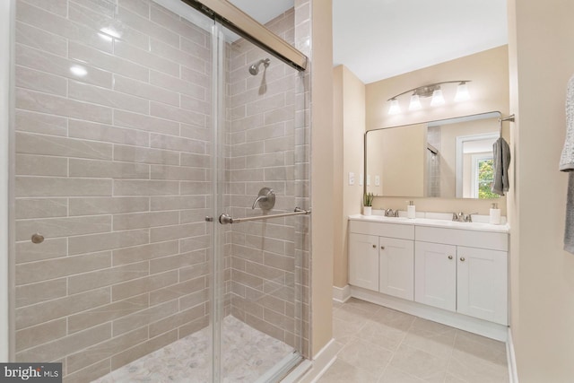 bathroom featuring double vanity, tile patterned floors, a sink, and a stall shower