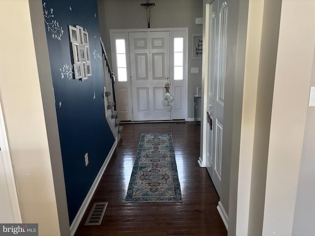 entryway featuring wood-type flooring, baseboards, visible vents, and stairs