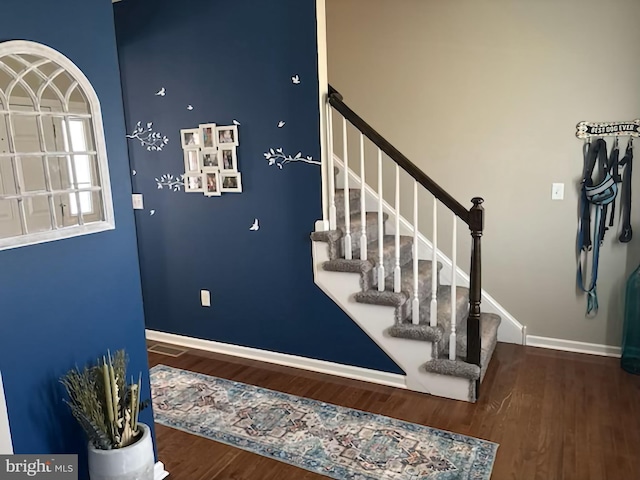staircase with baseboards and wood finished floors