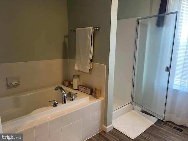 bathroom with visible vents, wood finished floors, a garden tub, and a shower stall