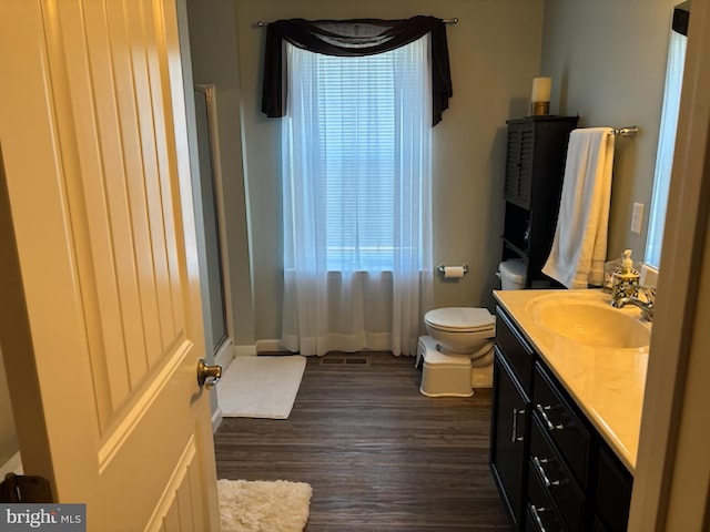full bathroom with vanity, wood finished floors, a shower, toilet, and baseboards