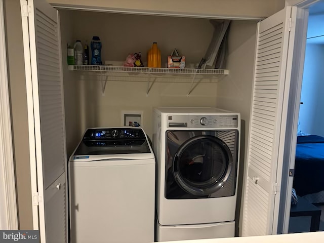 washroom with washing machine and clothes dryer and laundry area