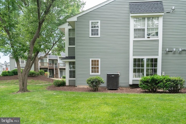 8607 Beekman Pl Unit 7B, Alexandria, VA 22309 - back of house with central AC, a yard, and roof with shingles