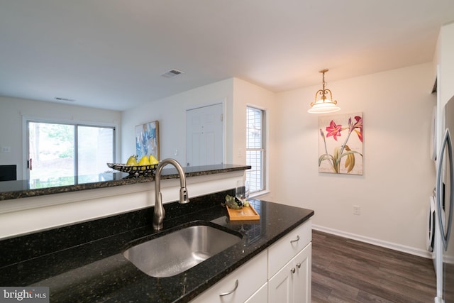 8607 Beekman Pl Unit 7B, Alexandria, VA 22309 - kitchen with a sink, white cabinetry, dark wood-style floors, dark stone countertops, and hanging light fixtures