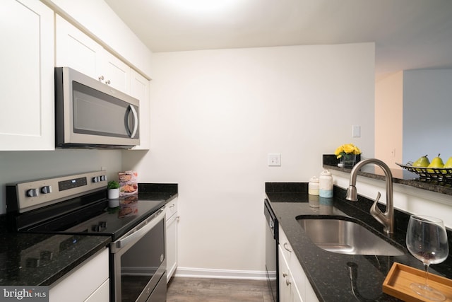 8607 Beekman Pl Unit 7B, Alexandria, VA 22309 - kitchen with appliances with stainless steel finishes, a sink, white cabinets, dark wood-type flooring, and dark stone counters